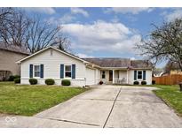 Charming single-story home featuring a well-maintained lawn, inviting curb appeal, and attached garage at 7347 Blue Creek S Dr, Indianapolis, IN 46256
