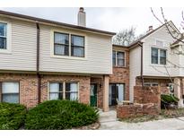 Attractive townhome featuring a brick facade, vinyl siding, and a cozy front patio at 9449 Maple Way, Indianapolis, IN 46268