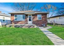 Charming brick home with a well-manicured lawn and inviting front porch, complete with a lovely walkway at 3618 Spann Ave, Indianapolis, IN 46203