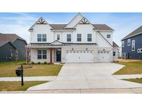 Two-story home with white siding, a two-car garage, brick accents, and a well-manicured lawn at 4241 Risen Star Way, Bargersville, IN 46106