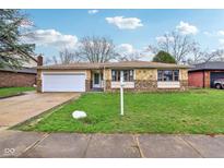 Charming ranch-style home featuring a stone facade, attached garage, and well-maintained lawn at 4911 Carry Back Ln, Indianapolis, IN 46237