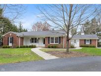 Charming brick home with covered porch and mature trees, offering classic curb appeal at 625 Mulberry St, Zionsville, IN 46077