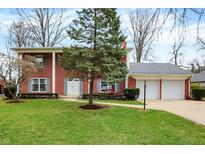 Charming two-story brick home with a well-maintained front yard and an attached two-car garage at 6537 Grosvenor Pl, Indianapolis, IN 46220