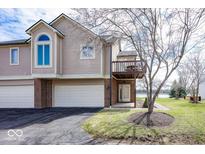 Charming townhouse with a two-car garage, balcony, and manicured front lawn at 7653 River Rd, Indianapolis, IN 46240