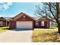 Charming brick home featuring an attached garage and well-maintained front yard at 8857 Limberlost Ct, Indianapolis, IN 46113