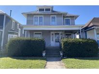 Charming gray two-story home with a covered porch and well-manicured landscaping at 925 E Main St, Muncie, IN 47305