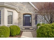 Charming front entryway with stone facade and beautiful landscaping at 999 Box Turtle Ct, Columbus, IN 47201