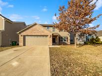 Charming two-story home with a brick facade, attached garage and a well-manicured lawn at 10432 Dark Star Dr, Indianapolis, IN 46234