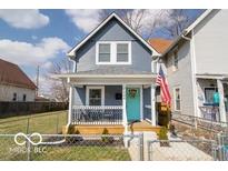 Charming two-story home featuring a welcoming front porch and a vibrant turquoise front door at 1444 English Ave, Indianapolis, IN 46201