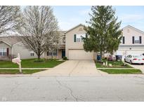 Charming home featuring a two-car garage, lovely landscaping, and beautiful flowering trees in a well-maintained front yard at 14974 Dry Creek Rd, Noblesville, IN 46060