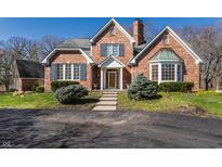 Beautiful red brick home featuring manicured lawn and stone pathway to front door at 1591 Preston Trl, Carmel, IN 46032