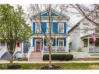 Charming blue two-story home with a welcoming front porch and neatly landscaped yard in a neighborhood setting at 2067 Rhettsbury St, Carmel, IN 46032
