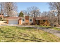 Charming home featuring brick accents, a covered porch, a lawn, and an attached garage at 251 Howard Rd, Greenwood, IN 46142