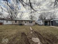 A single-story house with an expansive front yard and trees is pictured on an overcast day at 3812 S Ebright St, Muncie, IN 47302