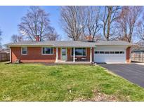 Charming brick home with a well-manicured lawn and attached garage, perfect for suburban living at 5430 N Sadlier Dr, Indianapolis, IN 46226
