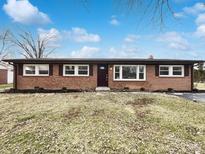 Charming brick ranch-style home with a well-manicured lawn and mature trees, under a bright blue sky at 7224 Rose Dr, Indianapolis, IN 46227