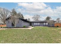 Stylish single-story home with a stone facade, manicured lawn, and a modern design aesthetic at 11 Bennett Rd, Carmel, IN 46032
