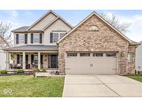 Charming two-story home featuring a brick facade, attached two-car garage, and a well-manicured front lawn at 11789 Langham Crescent Ct, Fishers, IN 46037