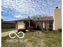 Charming single-story home with a well-maintained lawn and attached garage at 1836 Queensbridge N Cir, Indianapolis, IN 46219