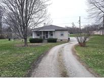Charming single-story home featuring a cozy porch and a long driveway with lots of trees at 2744 Walker Ave, Indianapolis, IN 46203