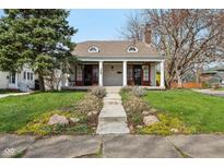 Charming single-story home featuring a welcoming front porch with red doors at 304 W 43Rd St, Indianapolis, IN 46208