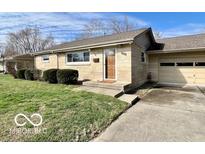 Charming single-story home featuring a brick facade, well-maintained lawn, and attached garage at 3154 Griffa Ave, Columbus, IN 47203