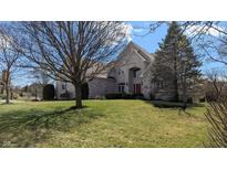 Charming two-story home with brick exterior, well-manicured lawn, and mature trees at 452 Twin Oaks Dr, Carmel, IN 46032