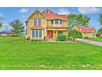 Charming yellow two-story home with red roof, inviting front porch, and well-maintained lawn at 5698 N County Road 375 E, Pittsboro, IN 46167