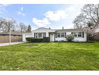 Charming single-story home with well-manicured lawn, inviting curb appeal, and attached garage at 5849 Brouse Ave, Indianapolis, IN 46220