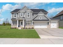 Charming two-story home boasts a three car garage and well-maintained front yard at 6027 Brentwood Trce, Brownsburg, IN 46112