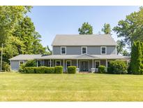 Charming two-story home featuring a covered porch and well-manicured lawn at 7372 Deerfield Dr, Greenfield, IN 46140