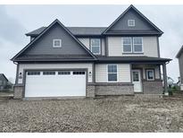 Two-story home featuring a brick base, gray siding, and a two-car garage with dark gray trim at 8893 Alexander Ridge Dr, McCordsville, IN 46055