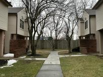 Exterior view of townhomes with sidewalk leading to a central courtyard and bare trees at 9452 Maple Way, Indianapolis, IN 46268