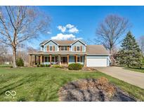 Charming two-story home featuring a welcoming front porch, attached garage, and well-manicured lawn at 9800 Oakleaf Way, McCordsville, IN 46055