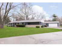 Charming ranch home with manicured lawn and separate two-car garage at 10101 Carrollton Ave, Carmel, IN 46280