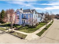 Charming blue two-story home with manicured landscaping and inviting curb appeal in a suburban neighborhood at 12895 Grenville St, Carmel, IN 46032