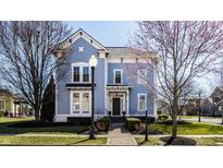 Charming blue two-story home with manicured lawn, brick walkway and an inviting front porch at 12895 Grenville St, Carmel, IN 46032