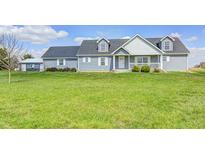 Charming two-story home with a covered front porch and a well-maintained lawn on a sunny day at 1502 W 525 N, Lebanon, IN 46052