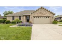 Charming brick home featuring a well-manicured lawn and an attached two-car garage, perfect for a Gathering at 1864 Holiday Pines Dr, Brownsburg, IN 46112
