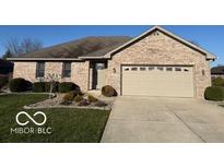 Charming brick home featuring an attached two car garage, well manicured lawn, and mature landscaping at 1864 Holiday Pines Dr, Brownsburg, IN 46112