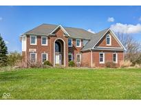 Beautiful two-story brick home with an arched entryway and a well-manicured lawn under a clear blue sky at 2009 W 250 N, Lebanon, IN 46052