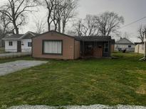 Charming single-story home with lawn and gravel driveway at 2233 W 28Th St, Anderson, IN 46016