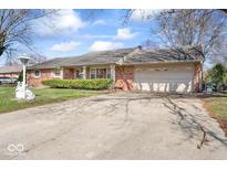 Charming single-story brick home featuring an attached two-car garage and well-maintained front yard at 3106 E 11Th St, Anderson, IN 46012