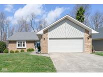 Charming single-Gathering home featuring a two-car garage, brick facade, and well-manicured front lawn at 3334 Eden Village Pl, Carmel, IN 46033