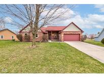Charming brick home with red roof, an attached two-car garage and well-manicured lawn at 528 Wind Skip Cir, Westfield, IN 46074