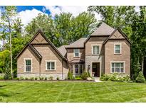 Beautiful brick two-story home with a well-manicured lawn and professionally landscaped front yard at 552 E 82Nd St, Indianapolis, IN 46240