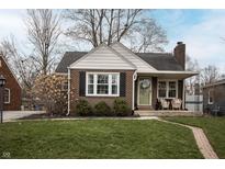 Charming brick home with a well-manicured front yard and inviting front porch featuring classic design and curb appeal at 5805 Indianola Ave, Indianapolis, IN 46220