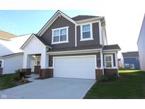 Charming two-story home featuring a two-car garage, gray siding, white trim, and a well-manicured lawn at 735 Locust Dr, Danville, IN 46122