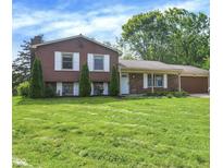 Charming two-story home with a well-manicured lawn and mature trees creating a serene setting at 8315 San Marcos Cir, Indianapolis, IN 46256