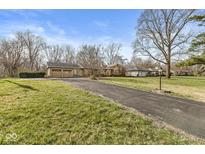 Asphalt driveway of a single-story home leading to a two-car garage on a grassy lot at 8606 Manderley Dr, Indianapolis, IN 46240